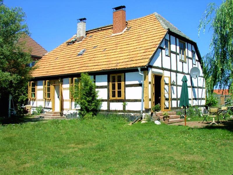 a large white and black house with a yard at Fischerhaus Godewind 60 qm in Altwarp