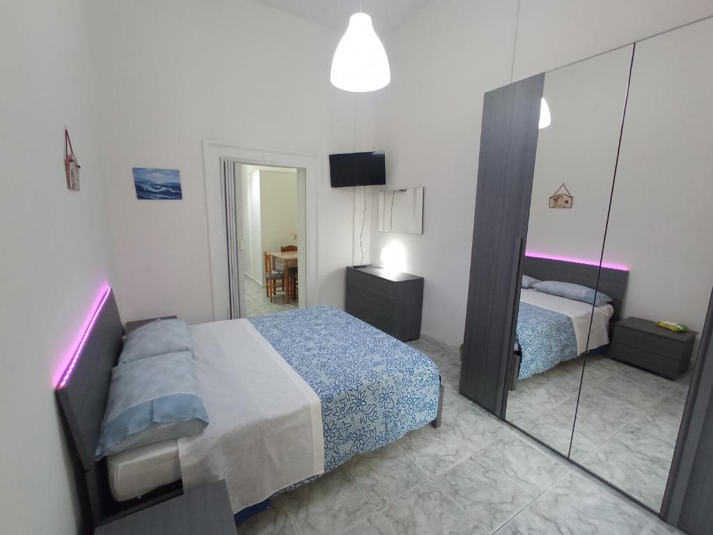 una piccola camera con letto e specchio di Flegrei Apartment a Napoli