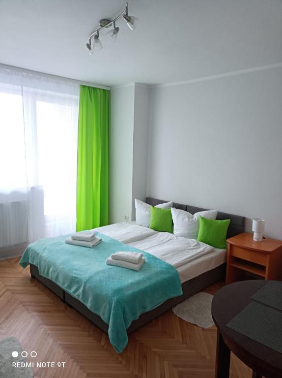 a bedroom with a large bed with green curtains at Dom gościnny Zosia in Świnoujście