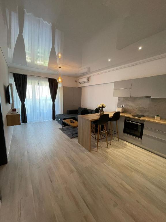 a kitchen and living room with a table and chairs at Mirage Sea Breeze Apartment in Mamaia