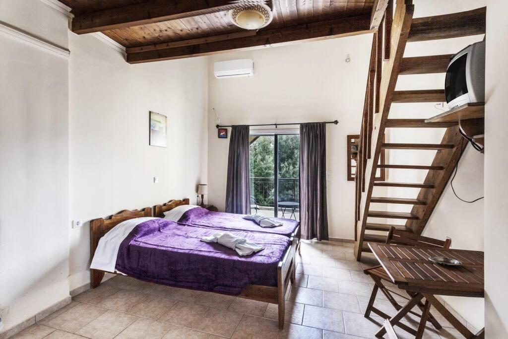 a bedroom with a purple bed and a staircase at Despina Studios 4 beds with loft and kitchenette # 8 in Raches