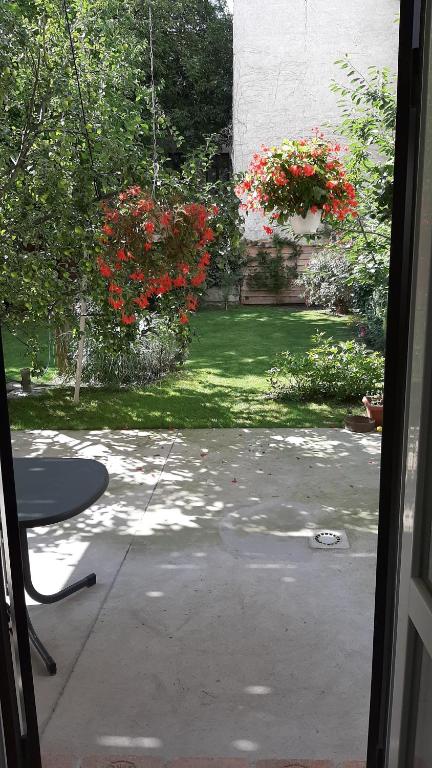 una vista esterna su un cortile con fiori rossi di Pia's Gardenview a Vienna