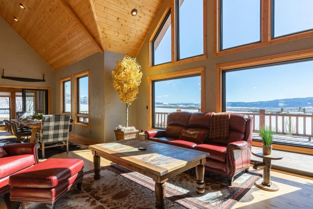 a living room with couches and a table and windows at MAJESTIC VIEWS FAMILY LODGE with Large Deck in Thayne