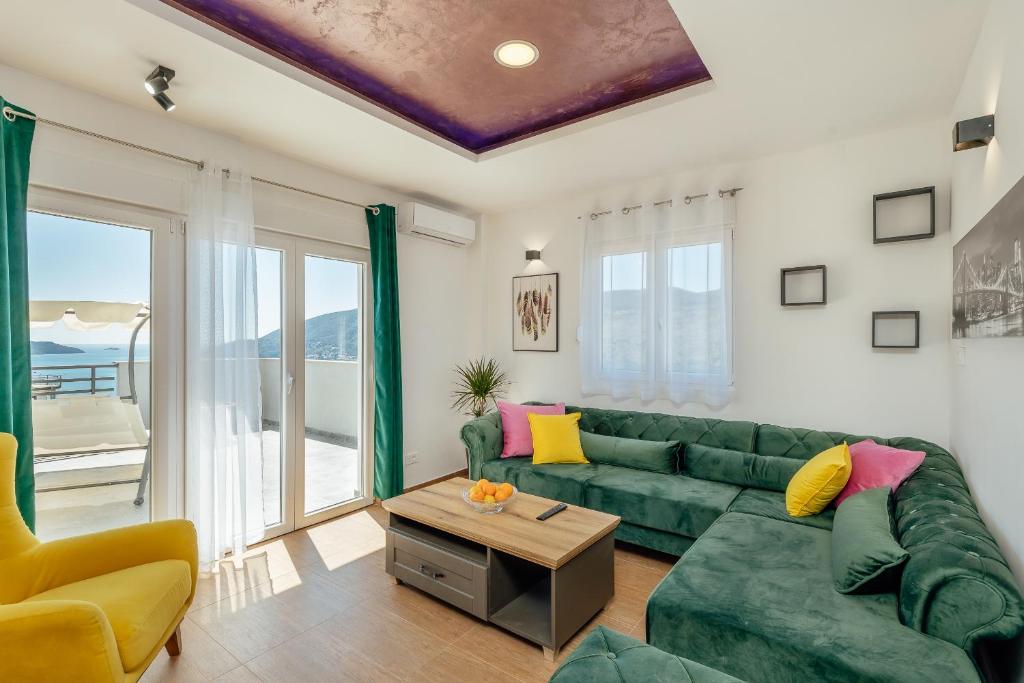 un soggiorno con divano verde e tavolo di Magnolija apartmani a Igalo