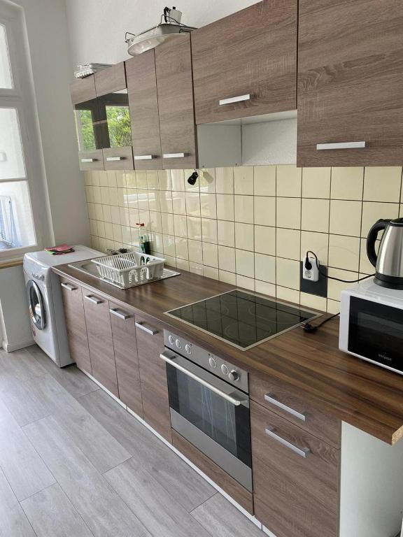 a kitchen with wooden cabinets and a stove top oven at Homefort in Düsseldorf