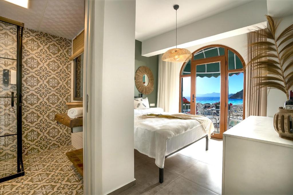 a bedroom with a bed and a large window at Liman Hotel Gümüslük - Adult Only in Bodrum City