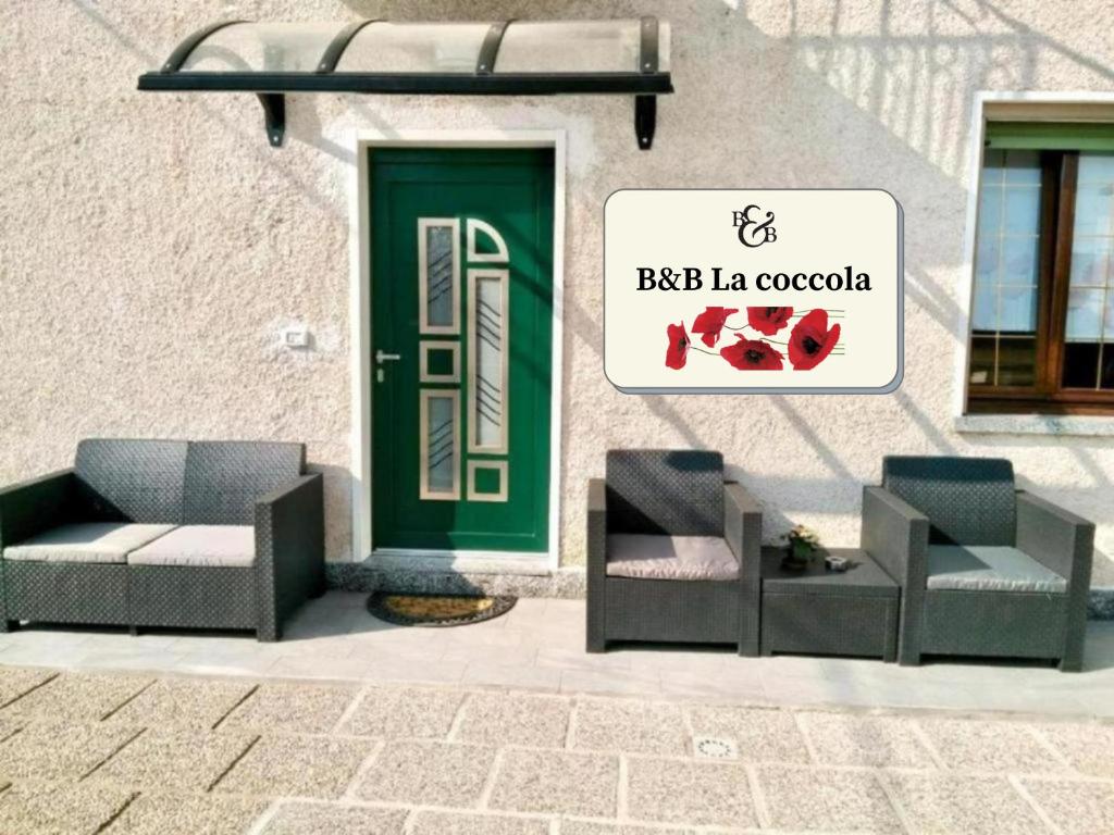 ein Gebäude mit zwei Stühlen und einer grünen Tür in der Unterkunft B&B La coccola in Lainate