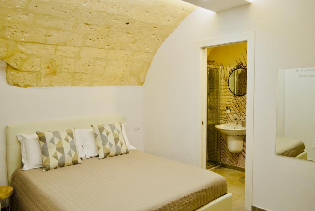 - une chambre avec un lit et un mur en pierre dans l'établissement Arvian B&B, à Bari