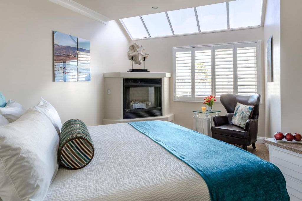 a bedroom with a large bed and a fireplace at SeaVenture Beach Hotel in Pismo Beach