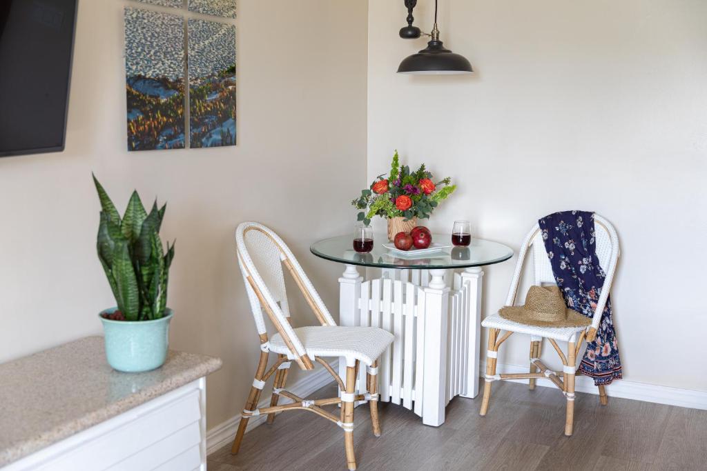 a small table with two chairs and a table with fruit on it at SeaVenture Beach Hotel in Pismo Beach
