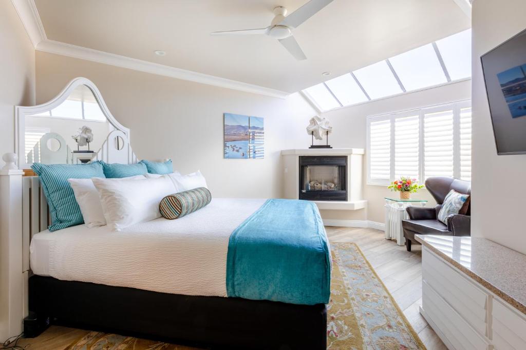 a bedroom with a king sized bed and a fireplace at SeaVenture Beach Hotel in Pismo Beach