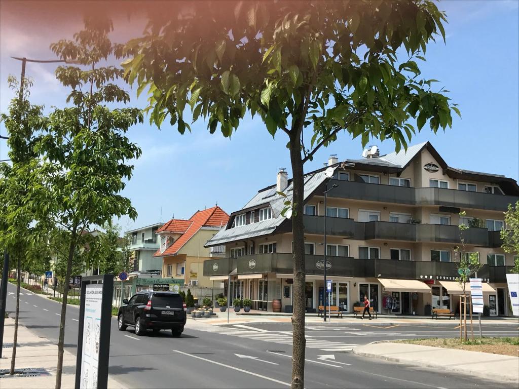 a car driving down a street next to a building at Relax Apartmenthouse in Hévíz