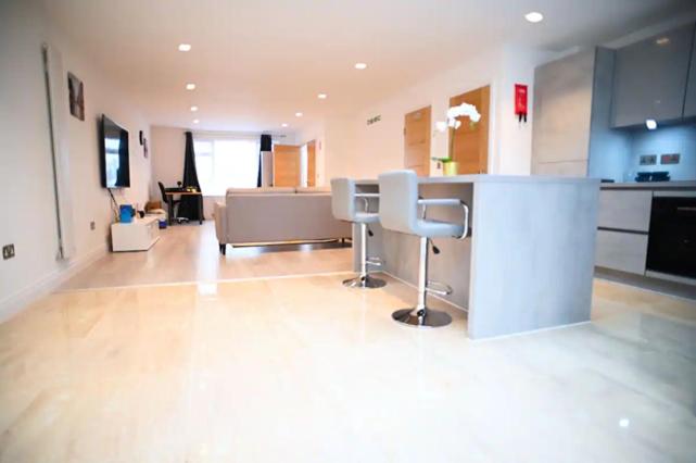 a kitchen with a counter and chairs in a room at A Brand New Massive 4 Bed Villa in Rainham Essex London in Rainham