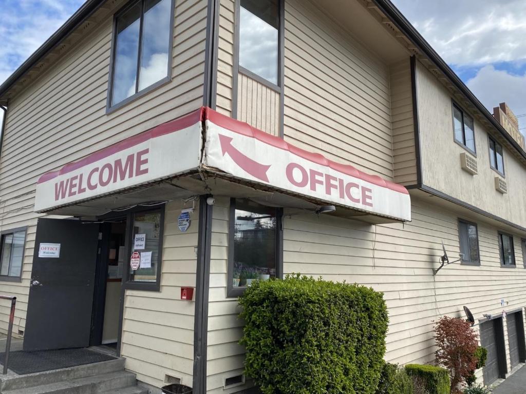 ein Willkommensbüroschild auf der Vorderseite eines Gebäudes in der Unterkunft Farwest Motel in Everett