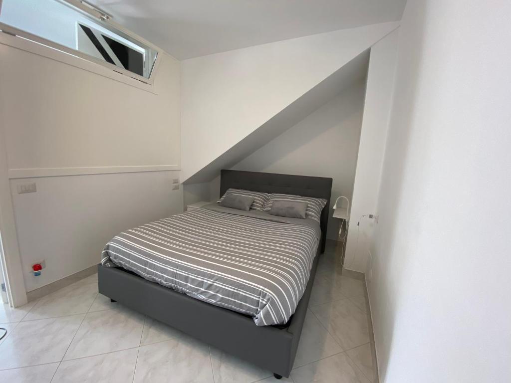 um quarto com uma cama num quarto branco em I Limoni Capri Apartment em Capri