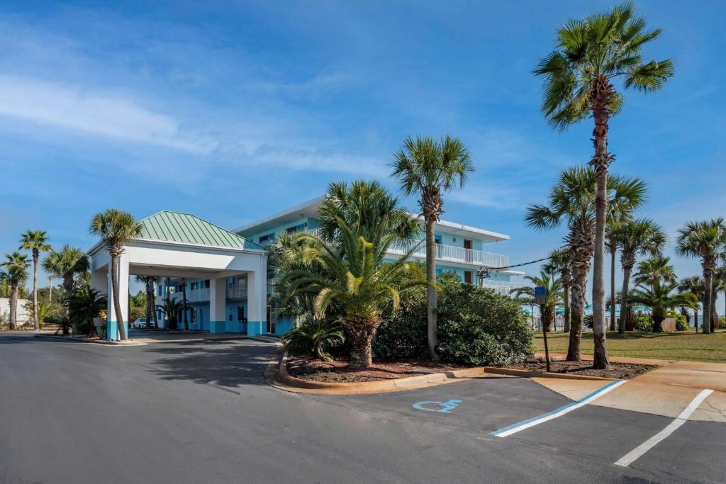 a building with palm trees in a parking lot at Best Western Navarre Waterfront in Navarre