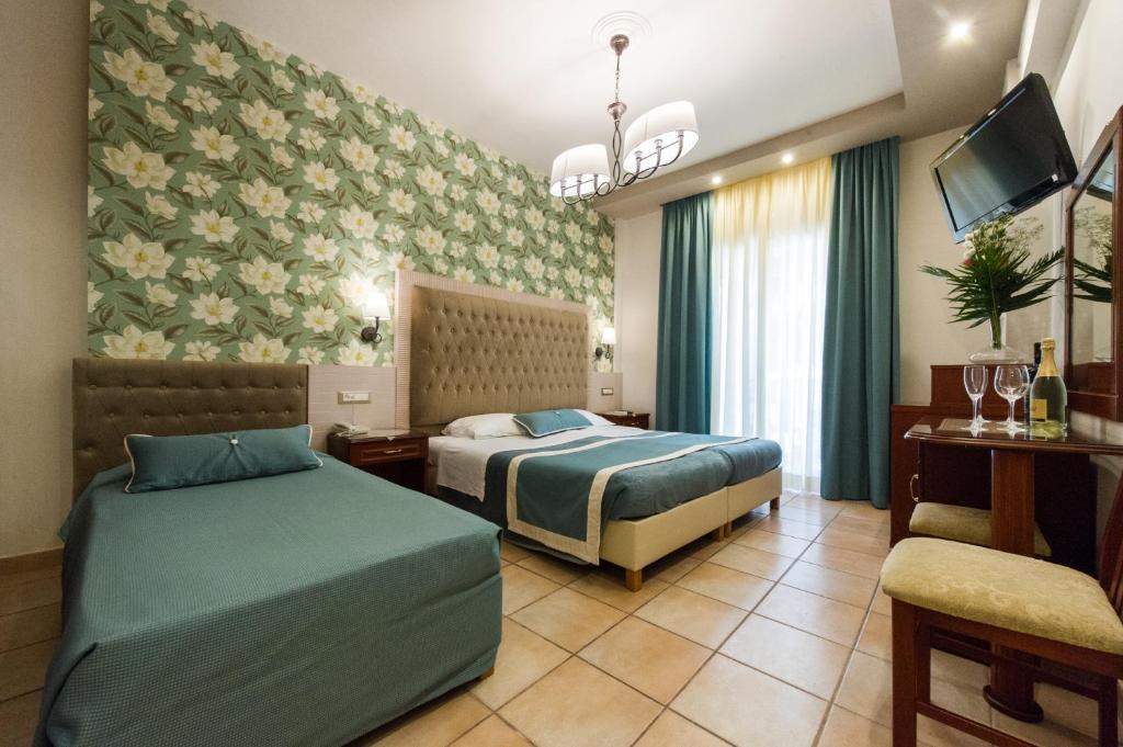 Postel nebo postele na pokoji v ubytování Olympic Hotel