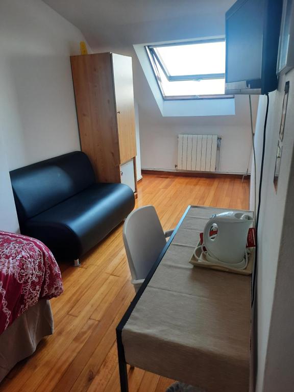 Habitación con cama, sofá y mesa. en Hospedaje Lopez, en A Coruña