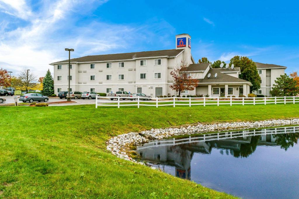 a building with a pond in front of it at Motel 6 Fishers, In - Indianapolis in Fishers