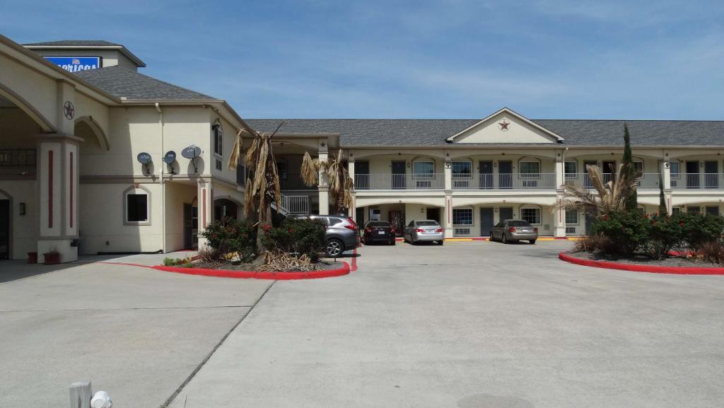 a large building with cars parked in a parking lot at Motel 6 Houston, TX – Willowbrook Mall in Houston