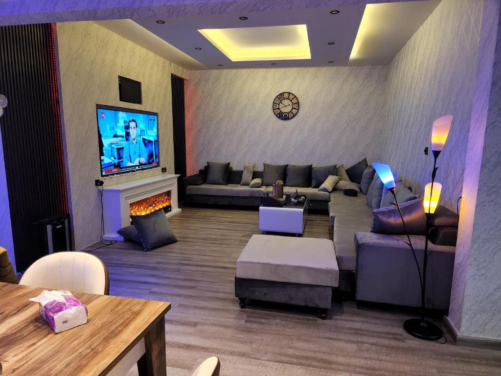 sala de estar con sofá y TV en شاليهات ميناء العرب, en Ras al Khaimah