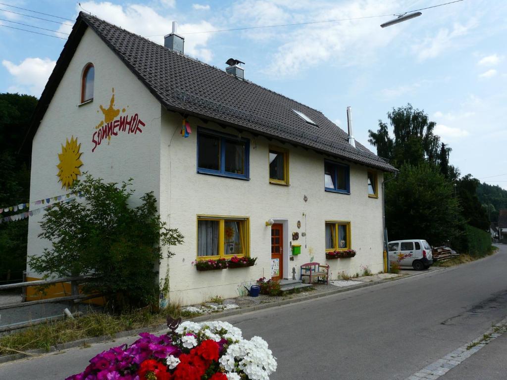 uma casa branca com flores à frente em Sonnenhof in Ziemetshausen bei Legoland Günzburg em Ziemetshausen