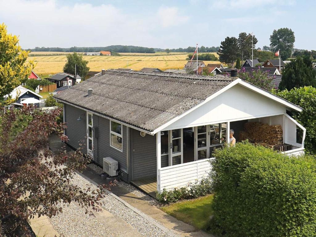 uma pequena casa cinzenta com um telhado branco em Holiday home Kerteminde X em Kerteminde