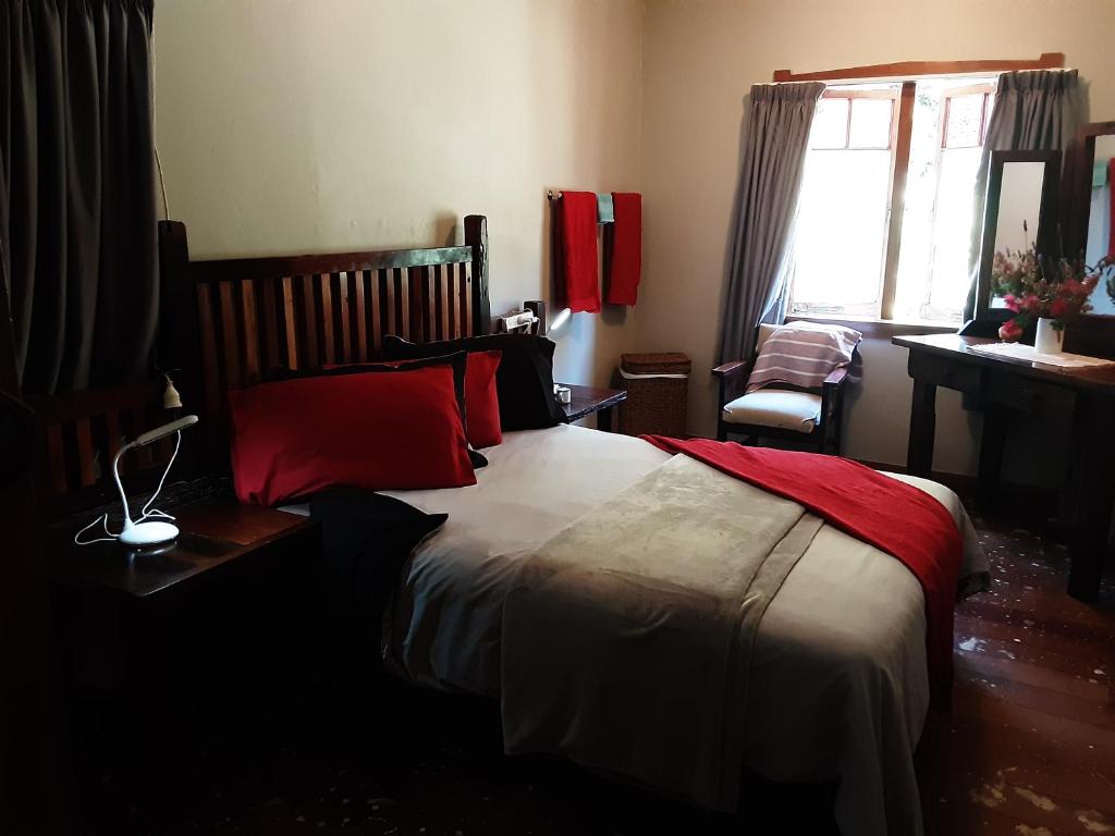 a bedroom with a large bed with red pillows at Share our home farm stay in Ruawaro