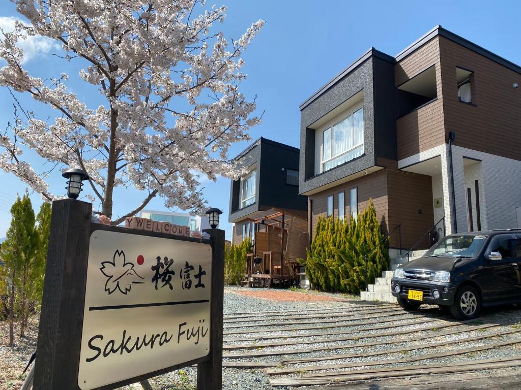 a sign in front of a house with a tree at SAKURA FUJI in Fujikawaguchiko