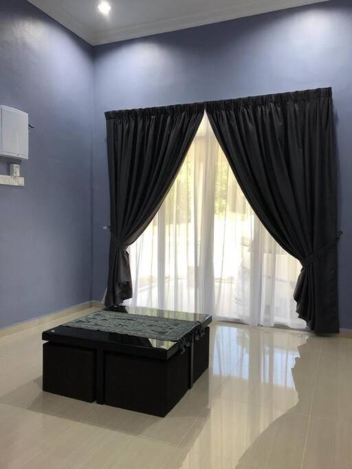 Habitación con ventana grande con cortinas negras. en afza Homestay Pak Bukit Besi en Dungun