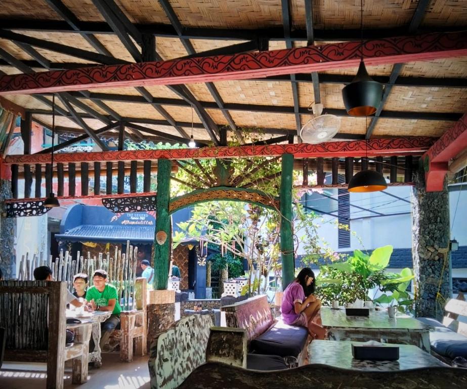 a woman sitting at a table in a restaurant at Jungle Inn Bukit lawang in Bukit Lawang