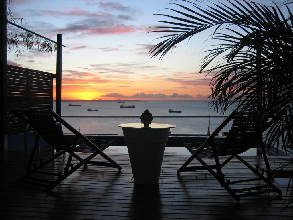 un pájaro sentado en una mesa en una cubierta al atardecer en Aram Yamí Boutique Hotel en Salvador