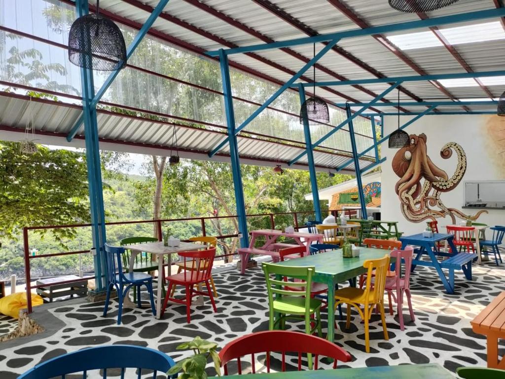 un restaurante con mesas y sillas coloridas en un patio en Baron Lighthouse Cottage & Eatery en Baron