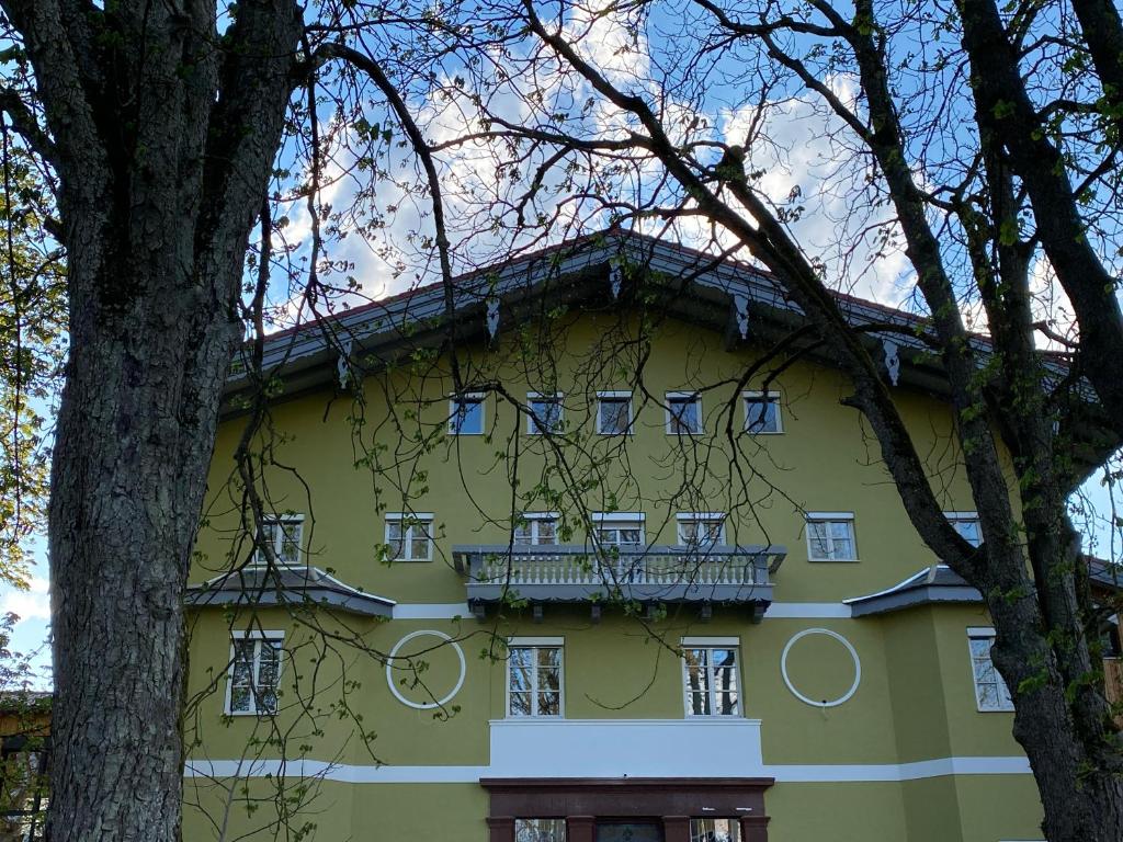 ein gelbes Gebäude mit einem Balkon an der Seite in der Unterkunft Villa Quintana in Künzing