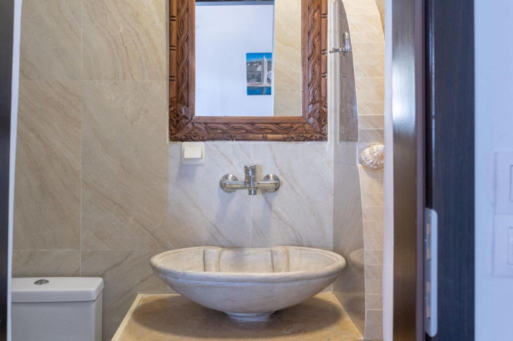 a bathroom with a bowl sink and a mirror at Alexandros by the Beach - Serifos in Livadakia