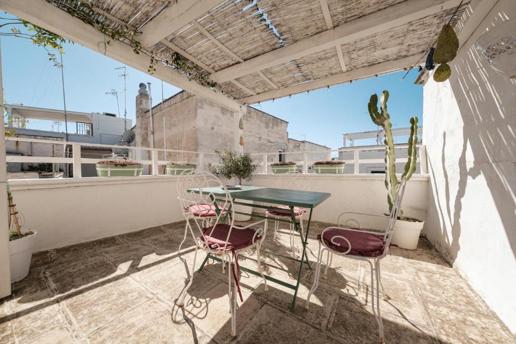 an outdoor patio with a table and chairs on a roof at Casa Chiasso Cacace in Monopoli