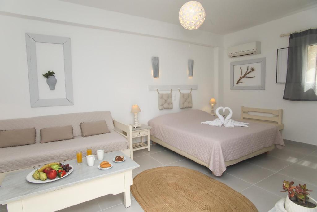 a bedroom with a bed and a table with a plate of fruit at Diplos Studios in Parikia