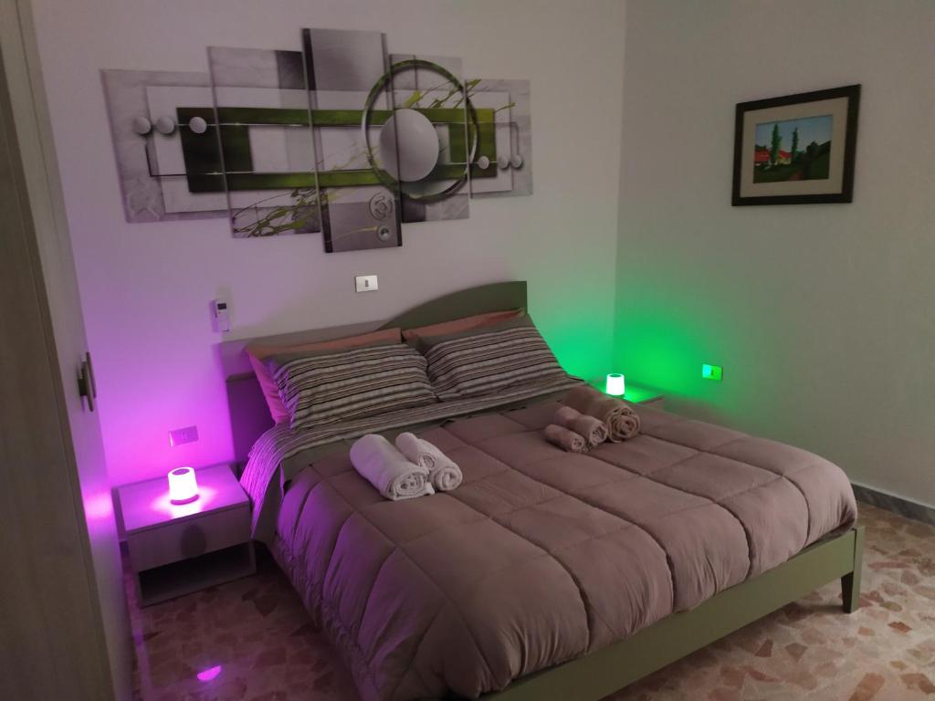 1 dormitorio con 1 cama con luces moradas y verdes en All inBasilicata Bed & Breakfast, en Baragiano