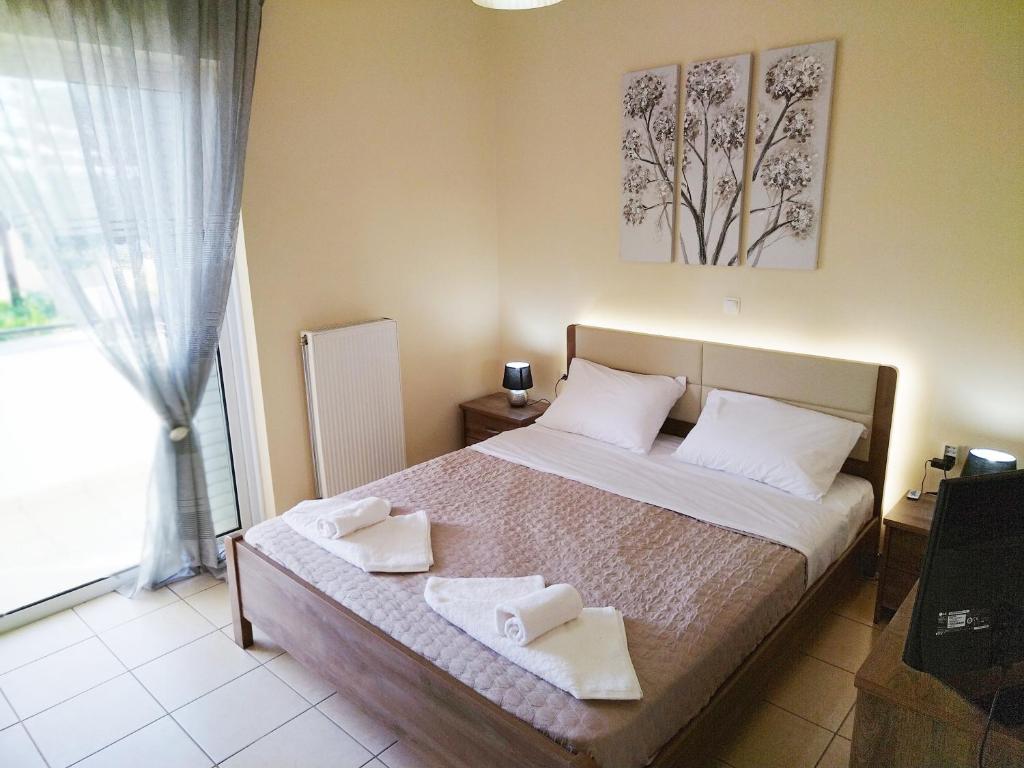 sypialnia z łóżkiem z dwoma ręcznikami w obiekcie Holiday & Business Furnished Apartments w mieście Mitikas