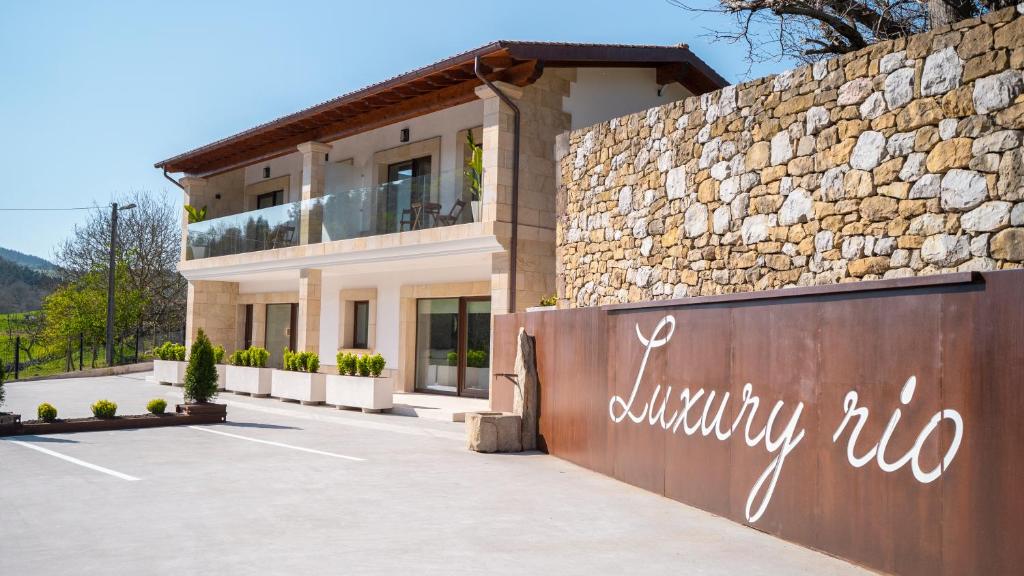 uma villa com uma parede de pedra e um edifício em Luxury Río em Santillana del Mar