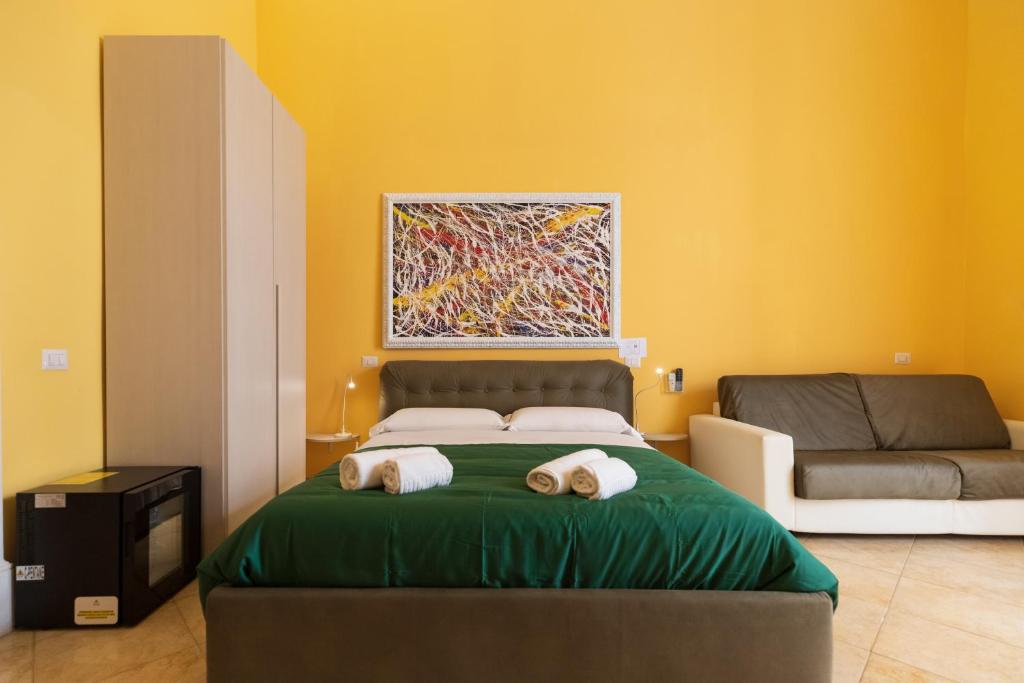 1 dormitorio con 1 cama con sofá y una pintura en Suites Trinità in Toledo street, en Nápoles