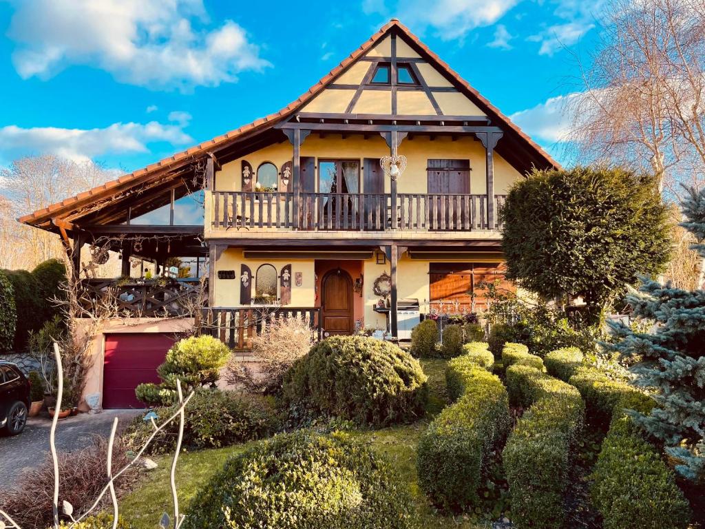 a house with a porch and a balcony at Bien être et détente chez côté campagne et jardin in Ohnenheim