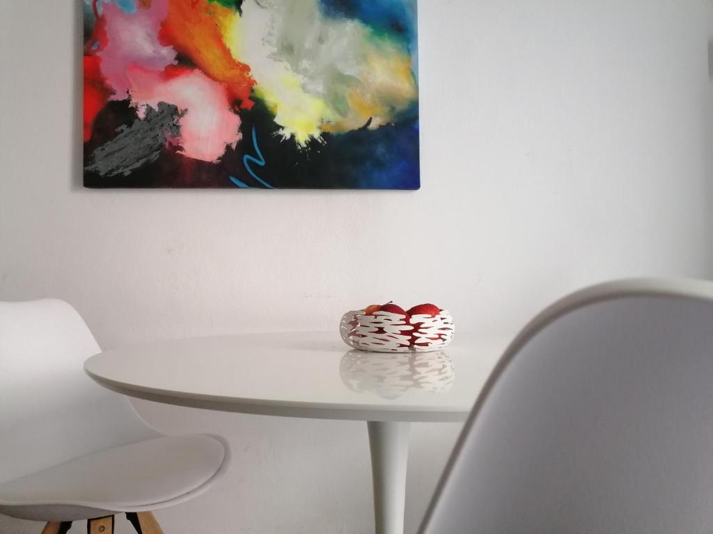 un tavolo bianco con un vaso sopra accanto a un dipinto di Casa sole a Stresa
