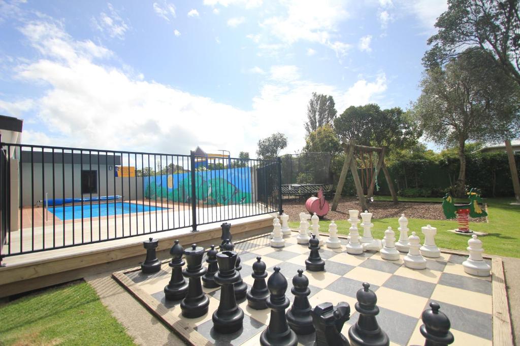a man playing chess on a chessboard in a playground at New Plymouth TOP 10 Holiday Park in New Plymouth