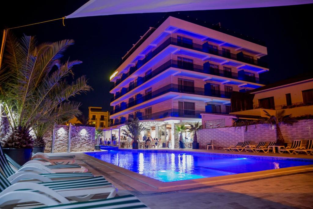 a hotel with a swimming pool at night at Almar Luxury in Mamaia Nord