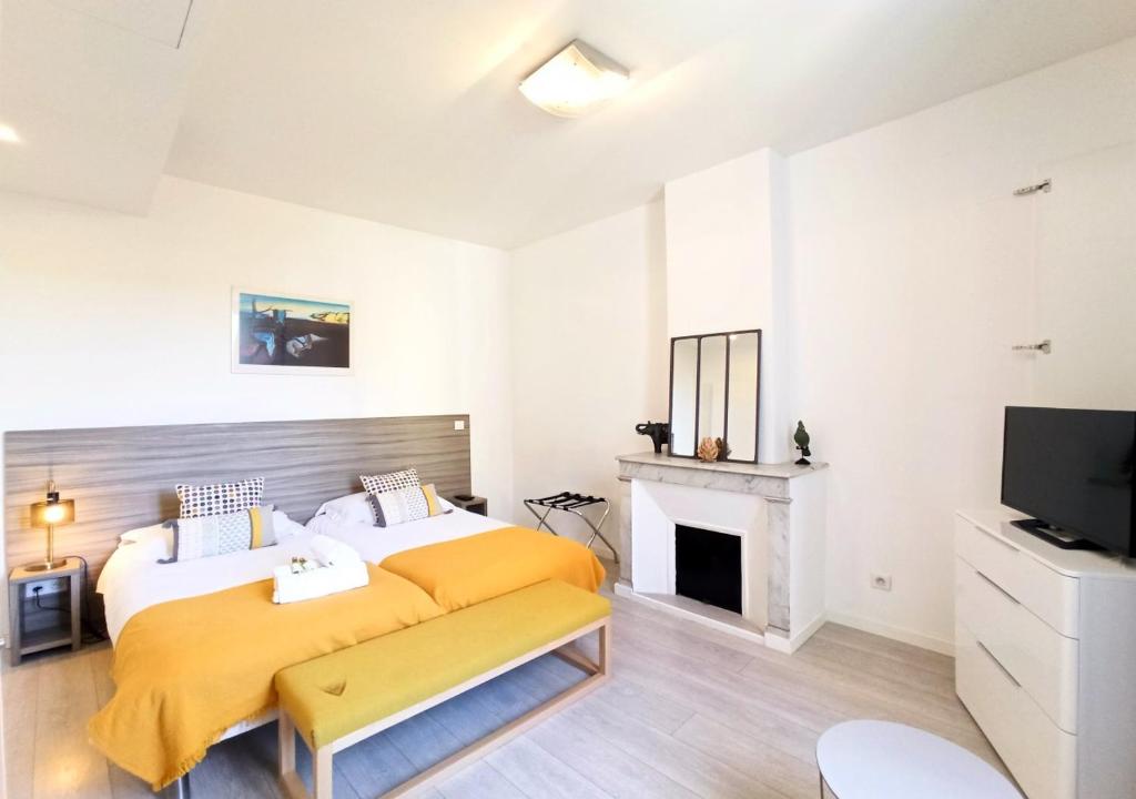 a bedroom with a large bed and a fireplace at Viva Riviera - 3 Rue Commandant André in Cannes