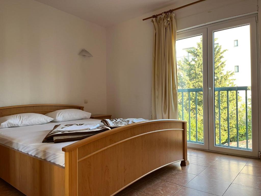 a bedroom with a bed and a large window at Apartments and Room MV in Petrovac na Moru