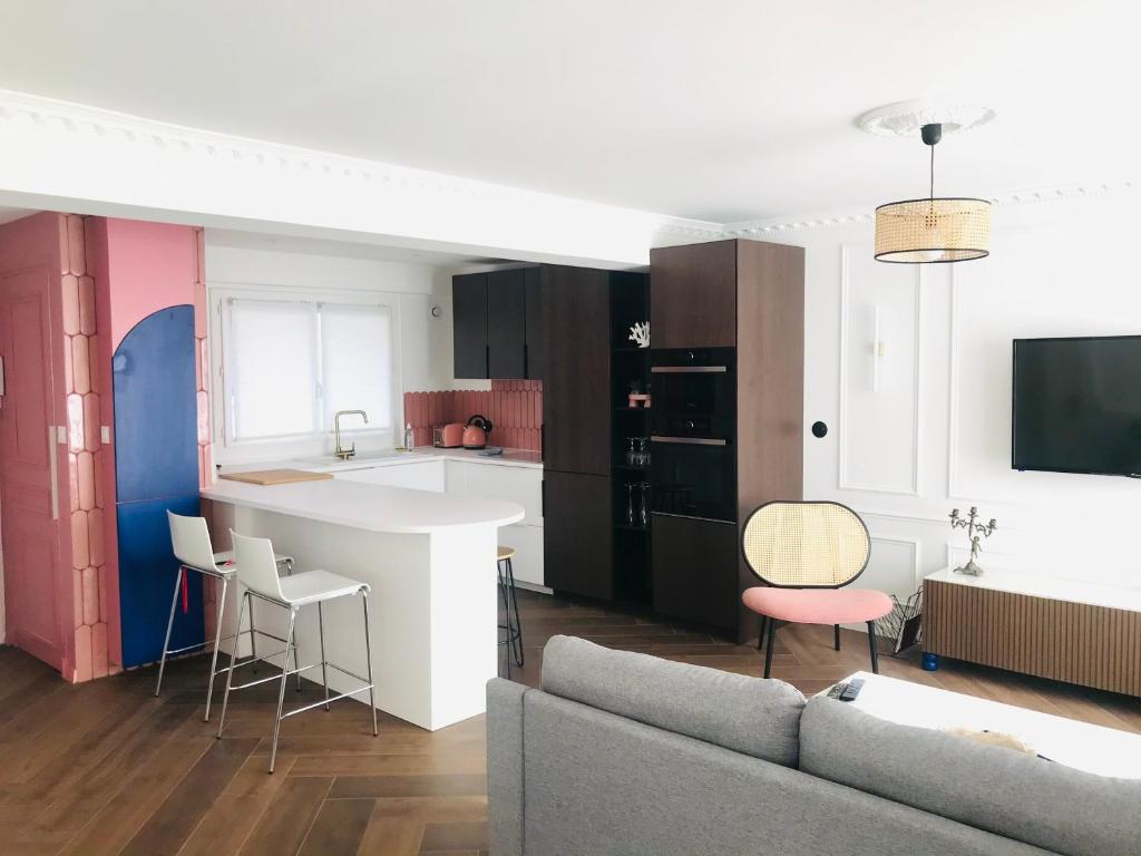 Una cocina y una sala de estar con un sofá y una mesa. en Nid Douillet 2 - Appartement cosy avec garage, en Grenoble