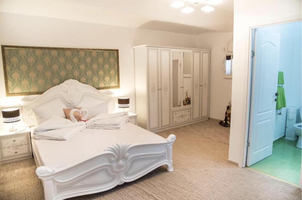 1 dormitorio blanco con 1 cama blanca grande con almohadas en Wall St House en Sibiu