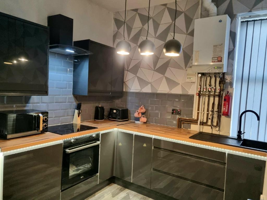 a kitchen with stainless steel cabinets and a sink at Blackpool Apartments in Blackpool